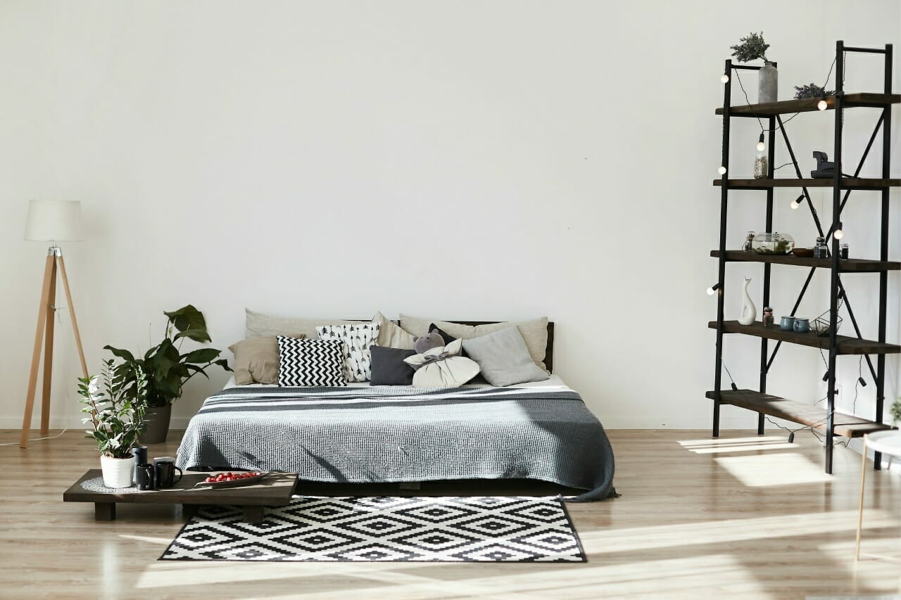 modern-bedroom-interior-of-colorful-bed-carpet-with-geometric-pattern-and-small-wooden-coffee-table