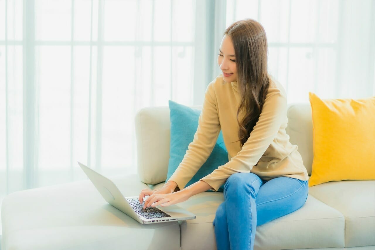 portrait-beautiful-young-woman-using-laptop-sofa-living-room