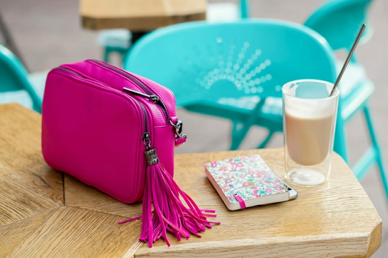 woman-stylish-accessories-on-table-in-cafe