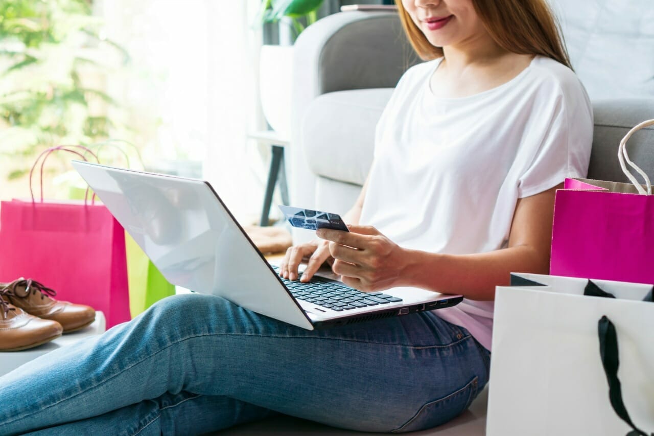 young-asian-women-inputting-card-information-while-shopping-online-with-computer-laptop-and-sitting-on-the-floor-with-postal-parcel-at-home-shopping-online-e-commerce-concept-close-up
