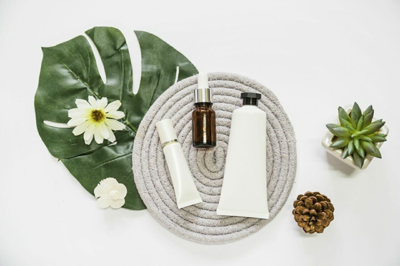 cosmetic-product-essential-oil-bottle-rope-coaster-with-flower-leaf-pinecone-cactus-plant