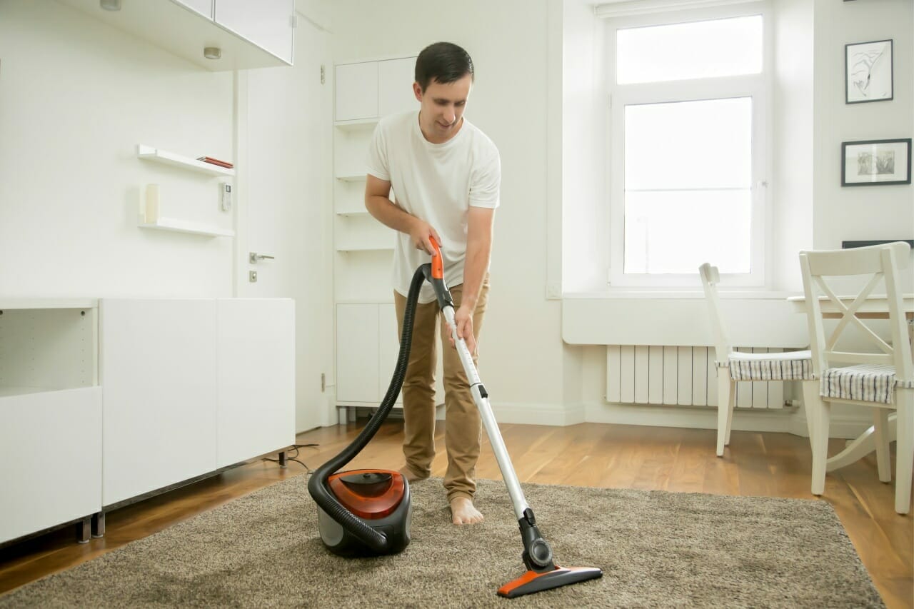 happy-smiling-man-cleaning-carpet