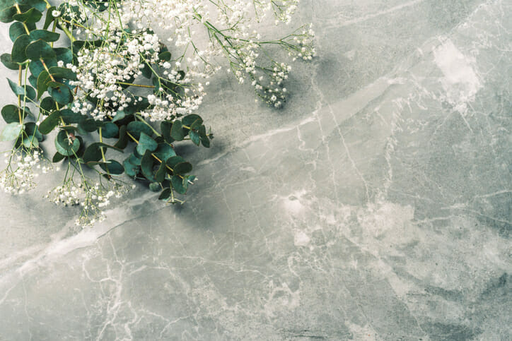 Flowers composition. Mock up. White gypsophila flowers and eucalyptus branches on marble background. Flat lay, top view, copy space. Wedding, birthday, anniversary bouquet. Woman day, Mother’s day